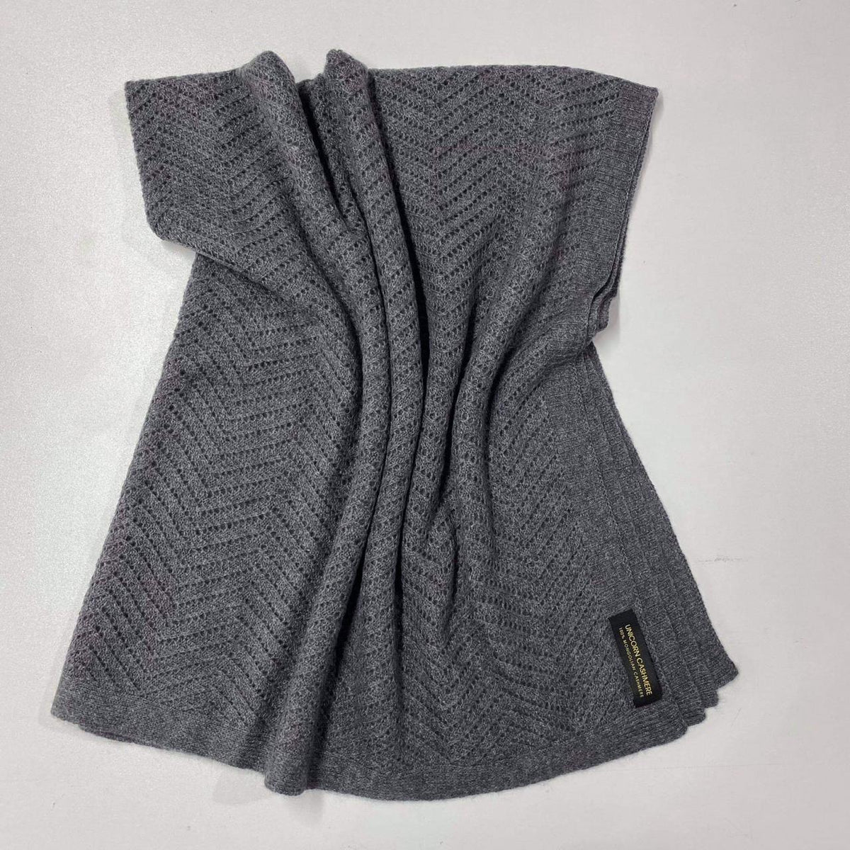 Dark Grey Tolui cashmere blanket laid flat, showing the chevron knit