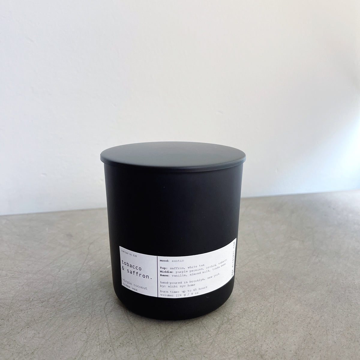 Tobacco and Saffron wooden wick candle in a matte black jar from Maison Creole Compass