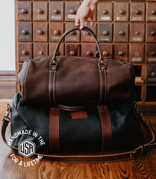 Nomad handmade top grain leather duffle bags in chocolate and black from Maison Creole Compass