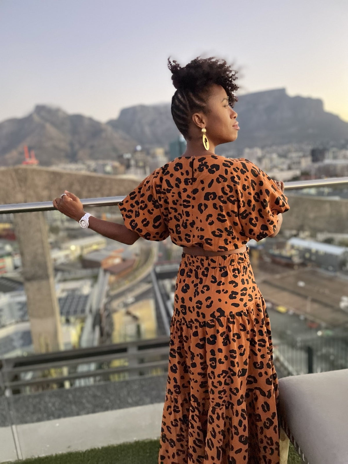 Nadege gazing toward Table Mountain from a Cape Town rooftop at golden hour